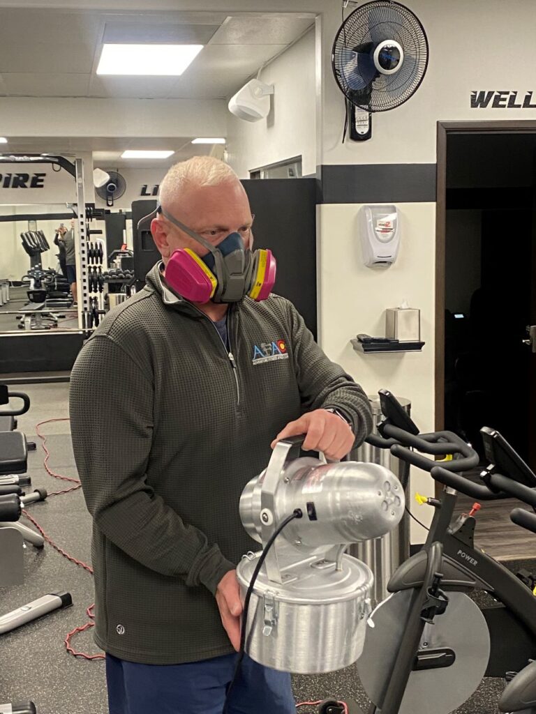 Man disinfecting AFAC gym with hospital-grade disinfectant