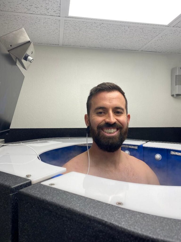 Man standing and smiling in cryotherapy chamber at AFAC gym