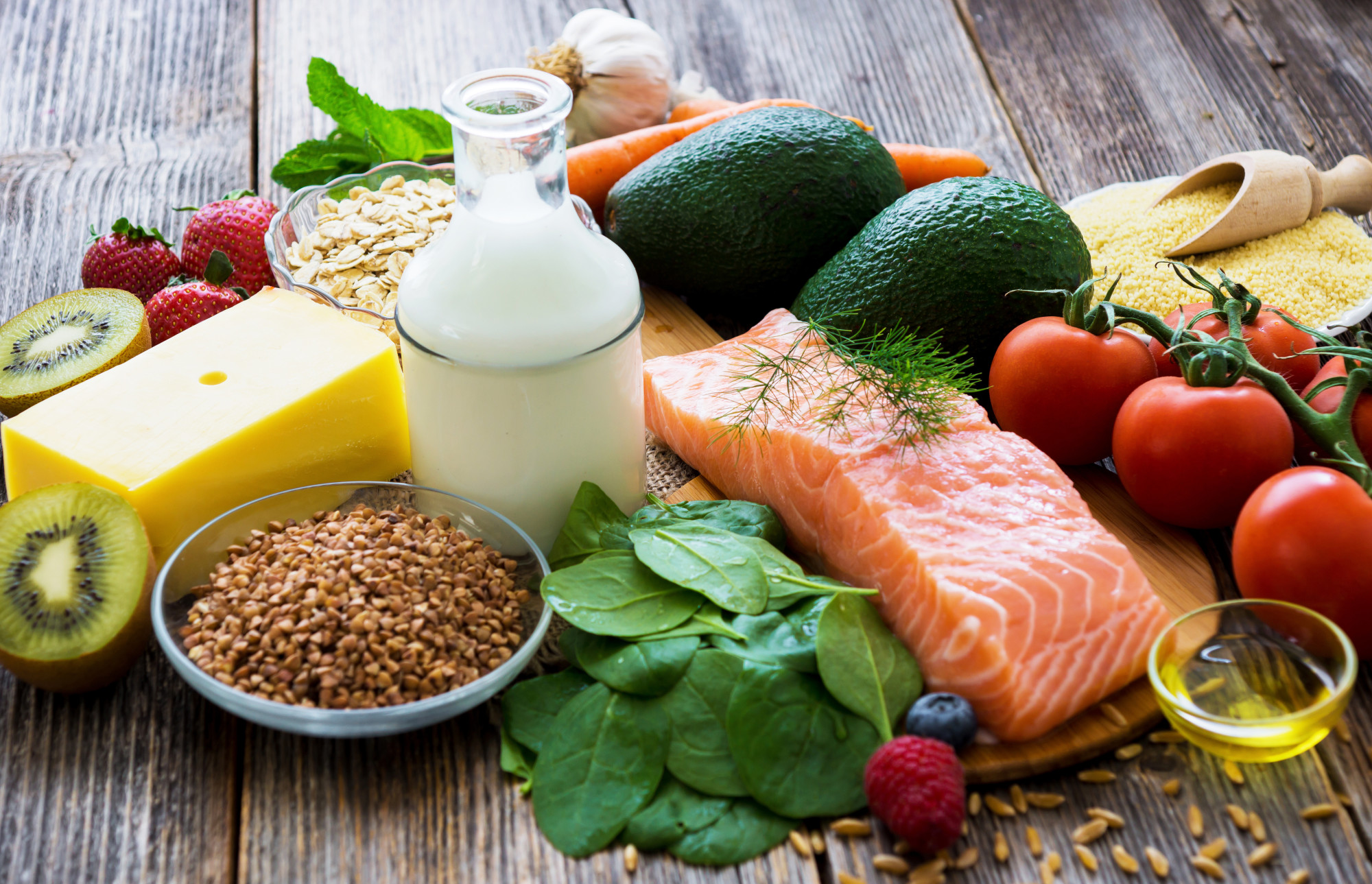 A photo of healthy foods including vegetables, fruits, milk, and salmon