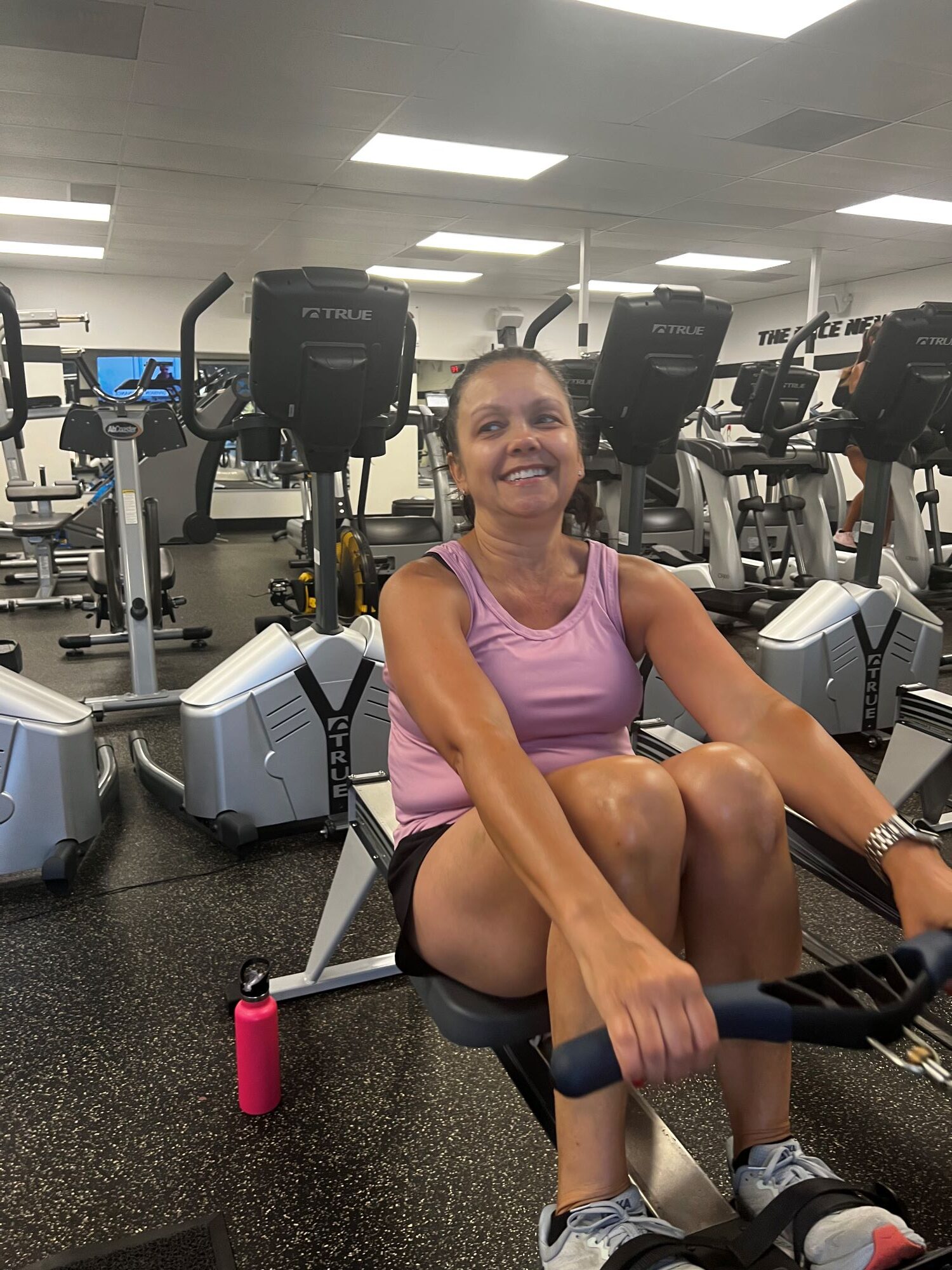 Smiling woman working out on rowing machine at AFAC gym