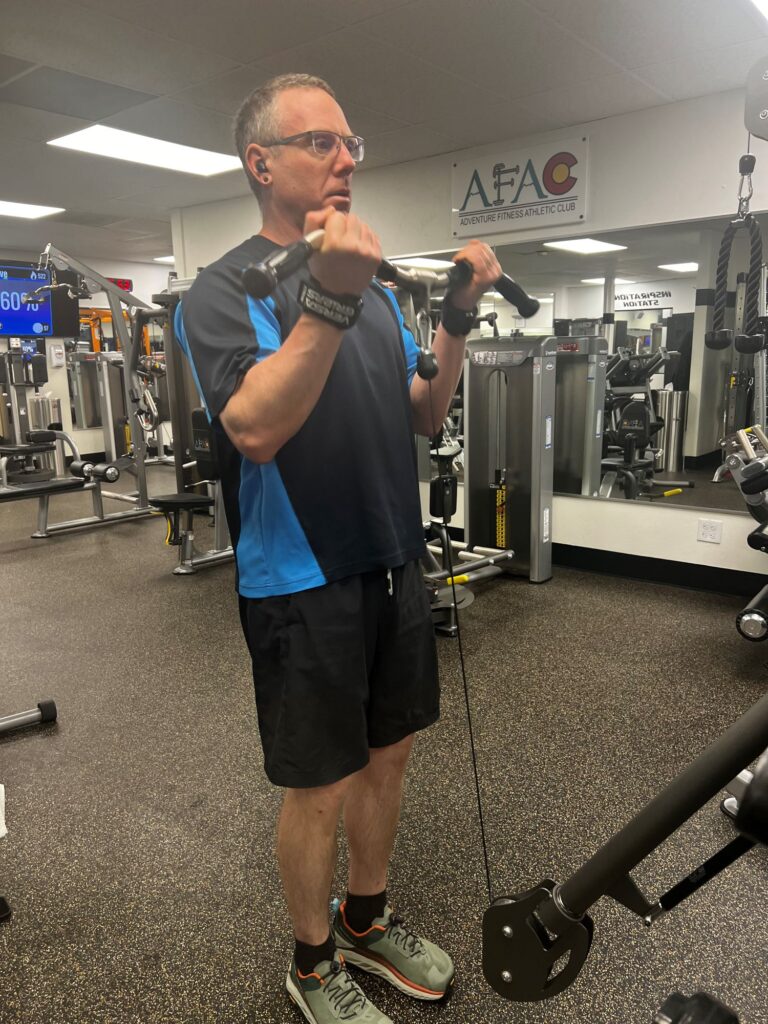 Man at AFAC gym working his arms on a cable machine