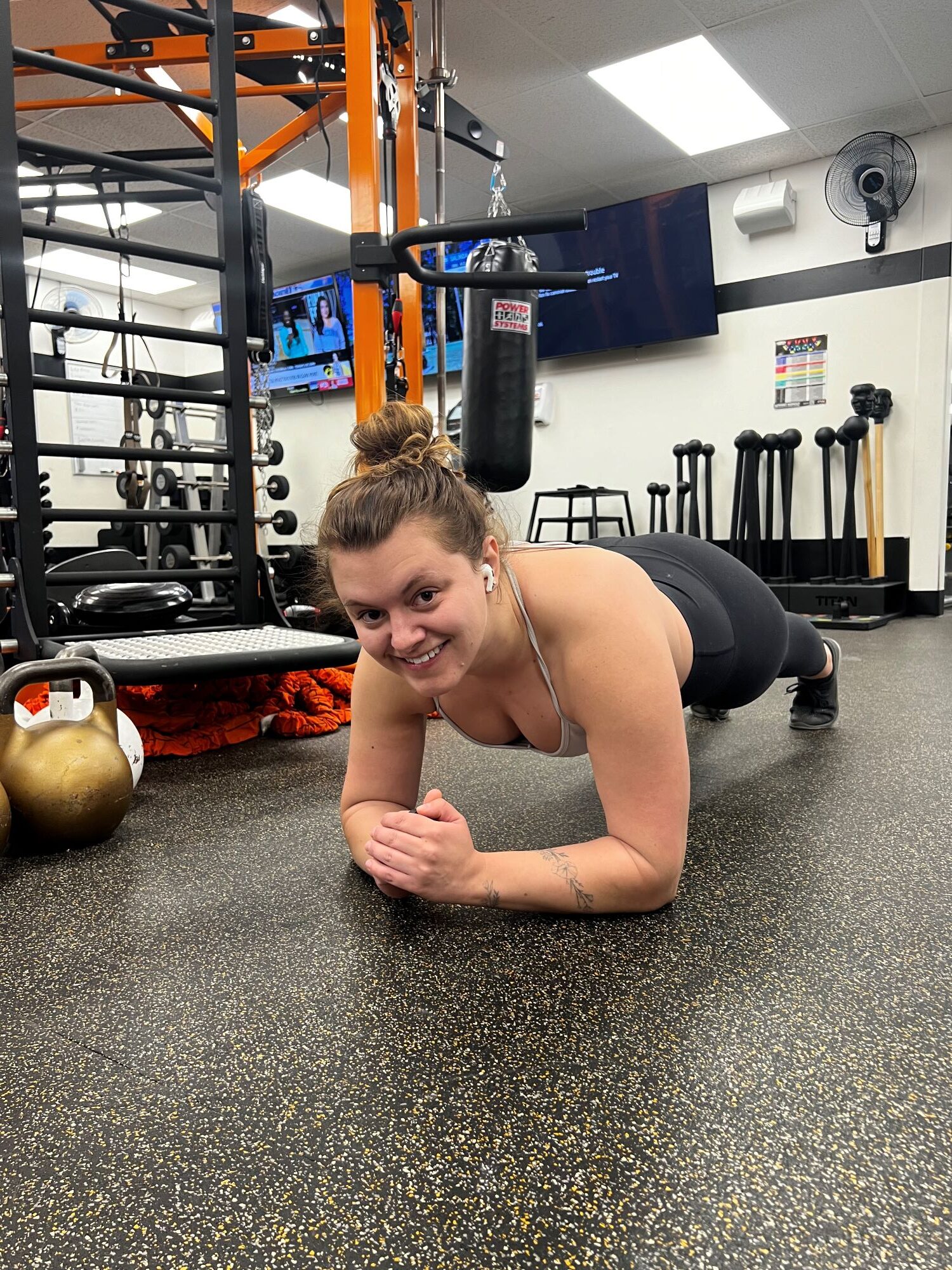 Smiling woman doing a forearm plank at AFAC gym