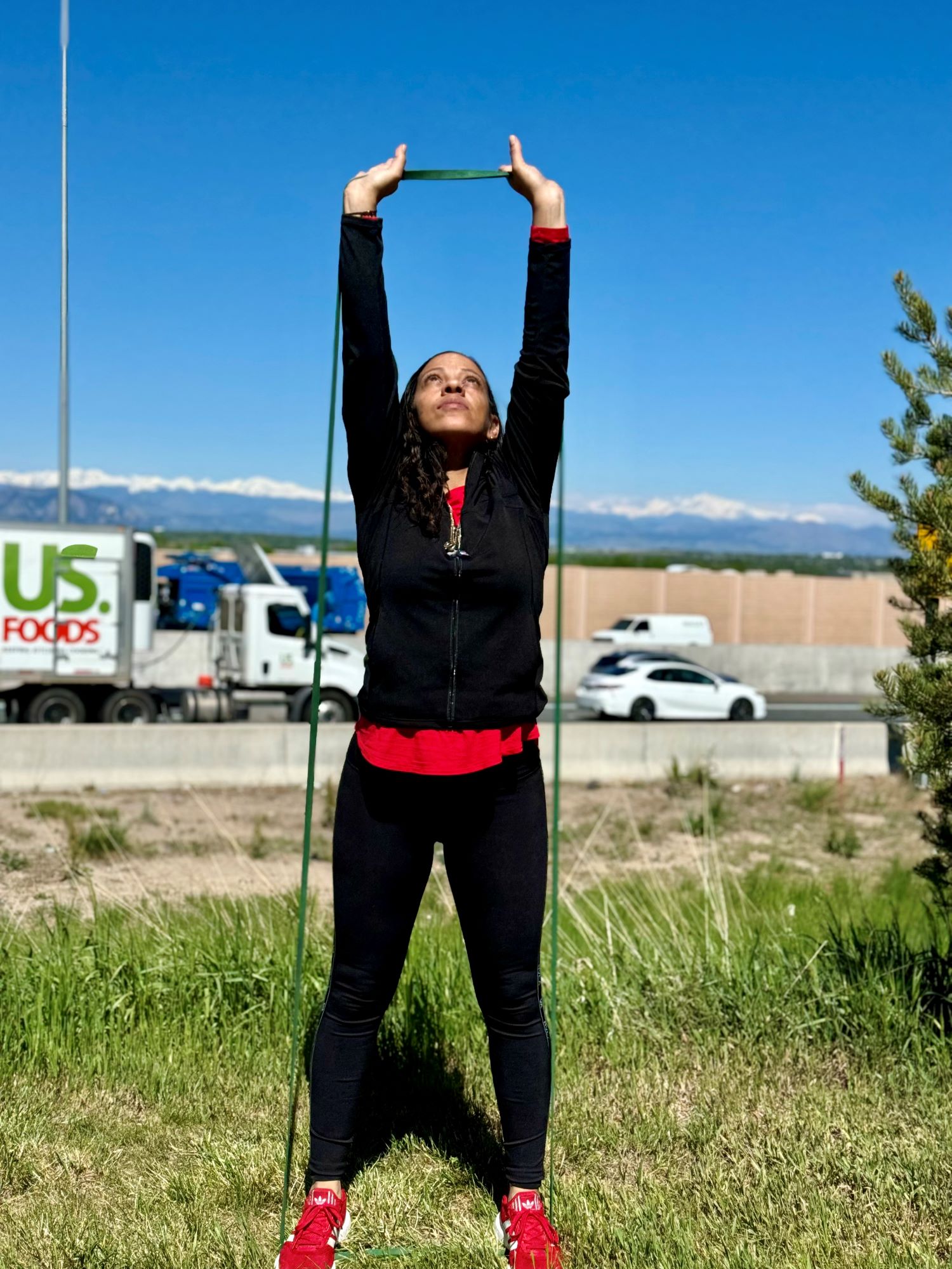 AFAC gym personal trainer exercises outside with an exercise band