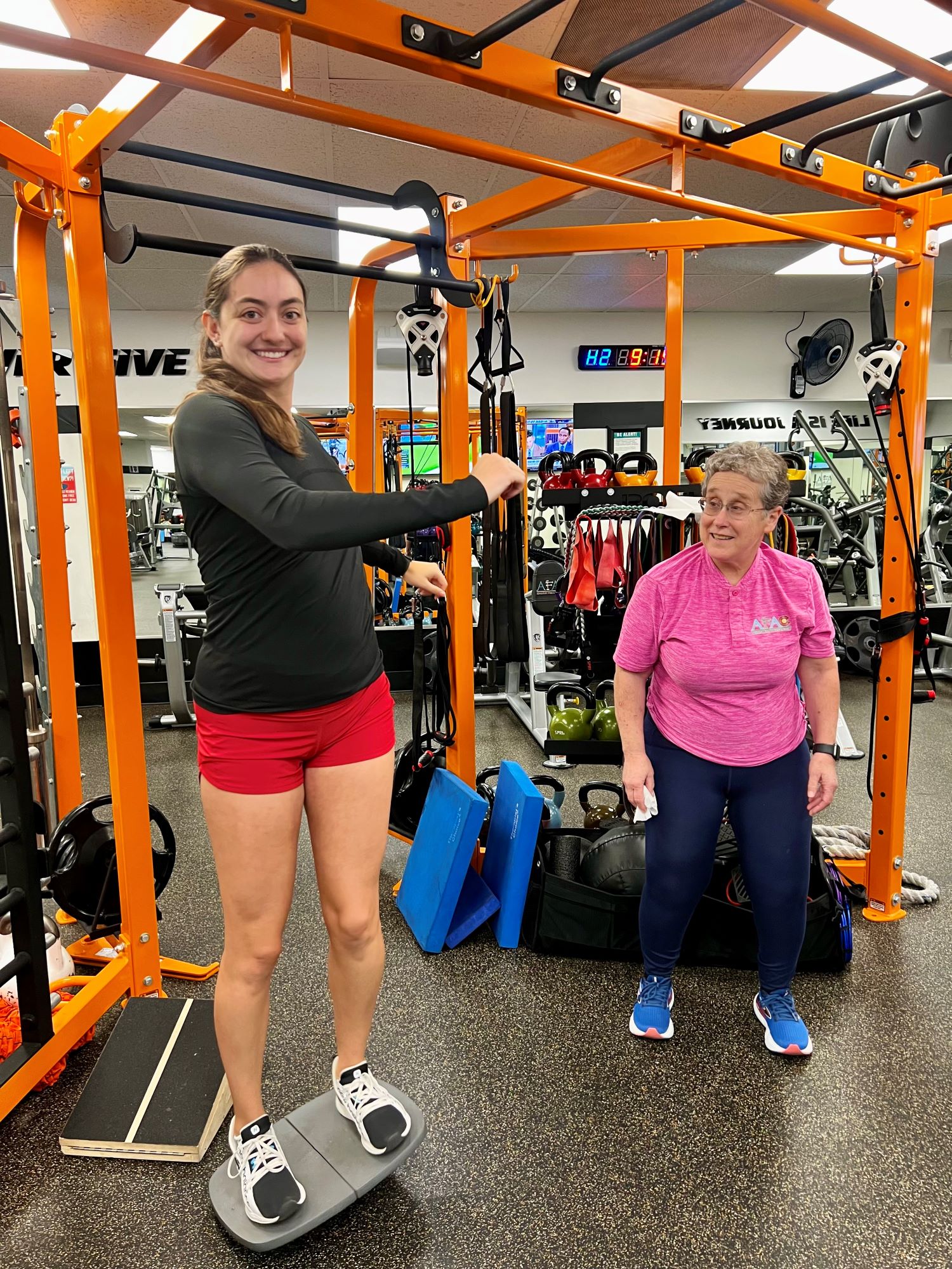 AFAC gym owner Susan Schaffner watches as a gym member exercises on a balance board