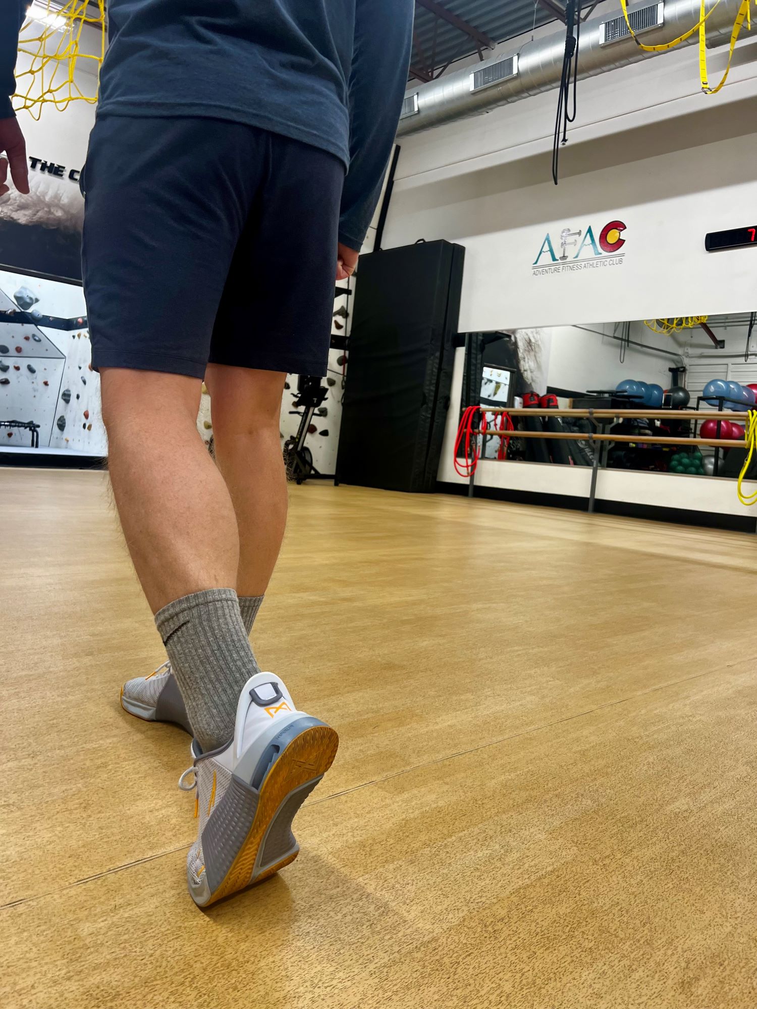 Photo of man walking in shorts inside AFAC gym showing a rear view from the waist down.