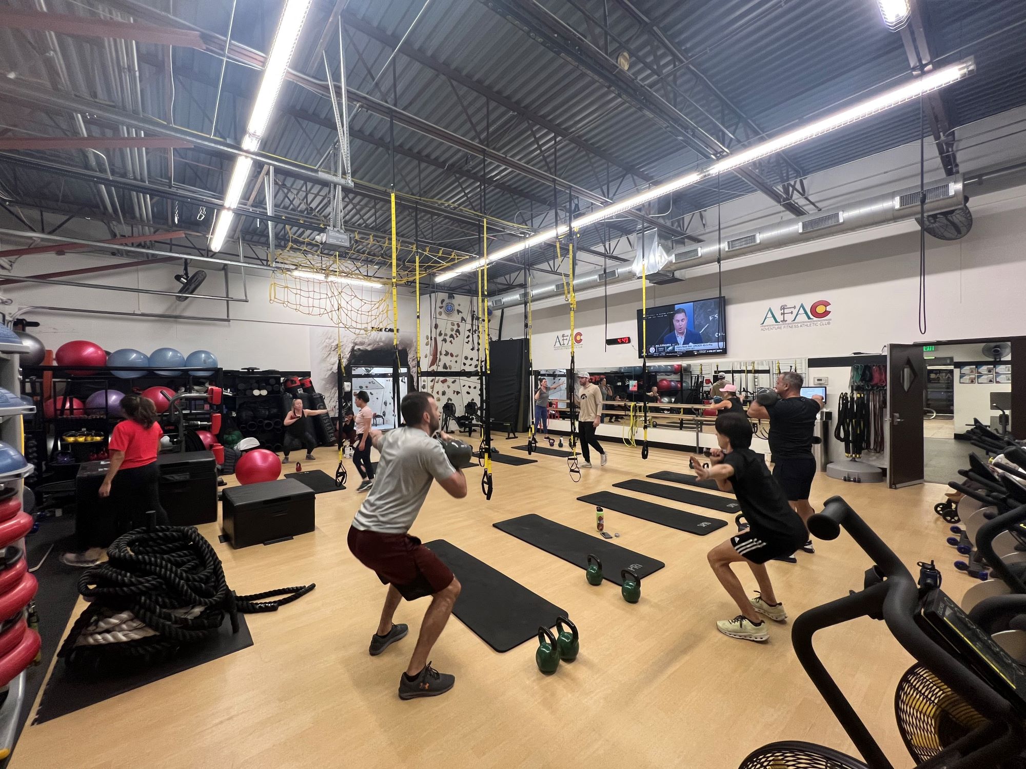 Several gym members exercise in a workout class at AFAC gym