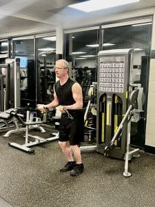 Man doing bicep curls on the cable machine at AFAC gym