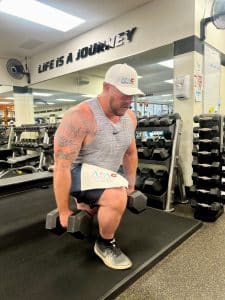 Man doing a dumbbell Bulgarian split squat at AFAC gym
