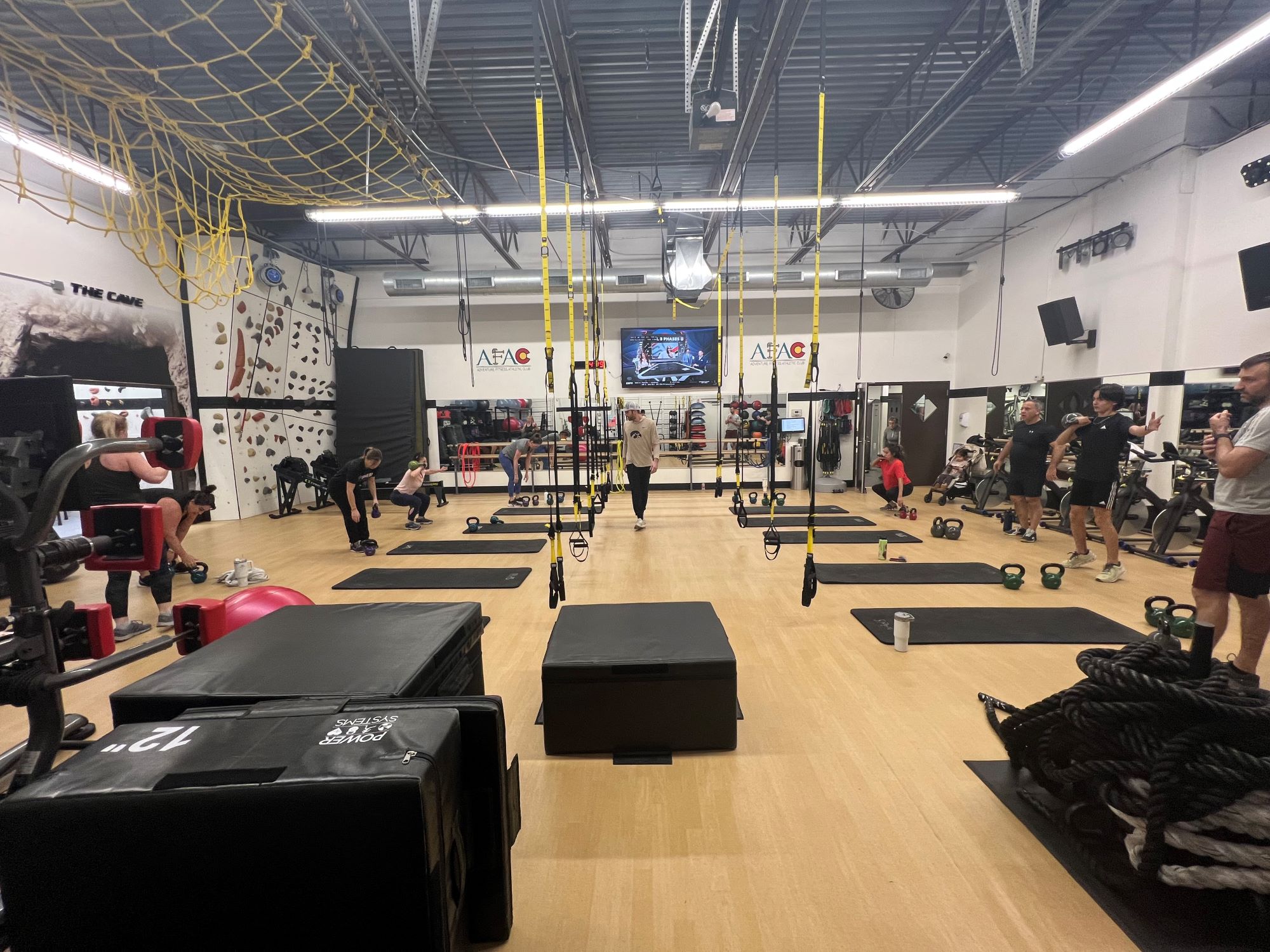 Instructor and several gym members work out during a fitness class at AFAC gym