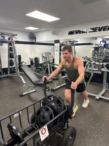Man pushes a workout sled at AFAC gym