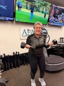 AFAC gym owner Susan Schaffner does biceps curls with dumbbells
