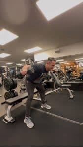 Man does a dumbbell reverse fly exercise at AFAC gym