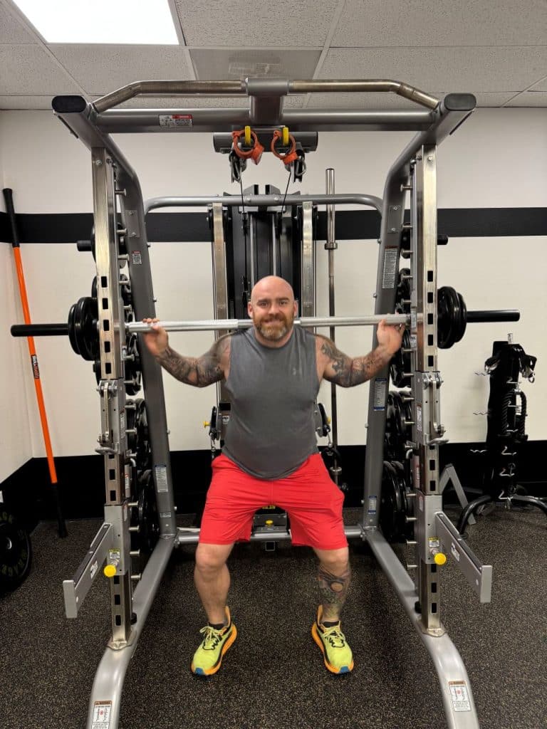 Man performs a back squat using a Smith machine at AFAC gym