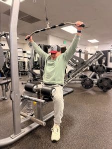 Man performs a lat pulldown exercise on a cable machine at AFAC gym