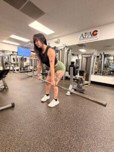 Woman doing deadlift with empty barbell at AFAC gym