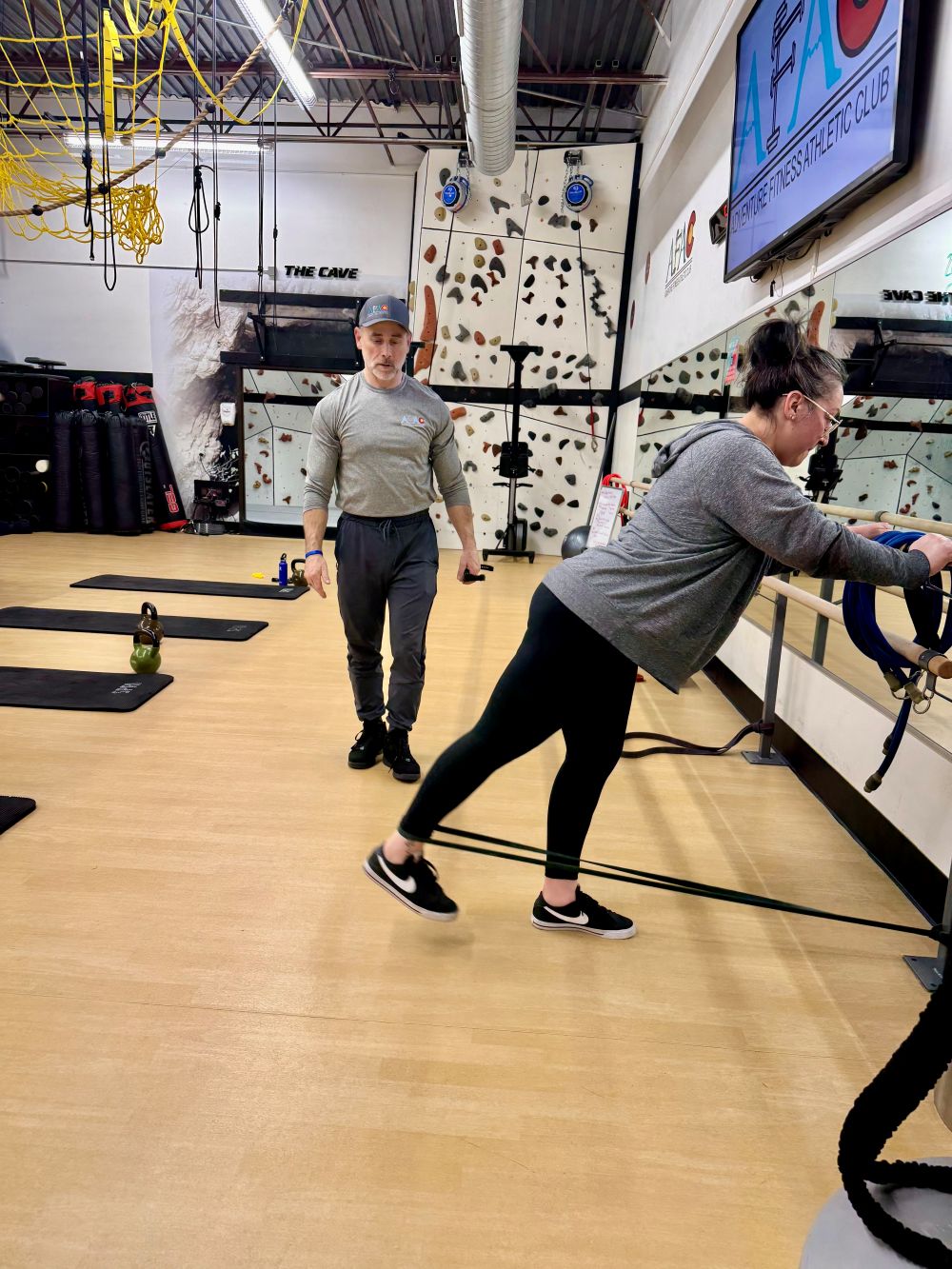 Woman doing kickbacks with personal trainer at AFAC gym