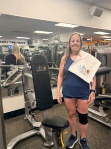 Smiling woman standing by a workout bench at AFAC gym