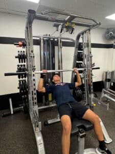 AFAC gym member does Smith machine bench press at AFAC gym