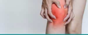 Close-up image of woman's knees with one knee highlighted in red and woman grabbing injured knee in pain