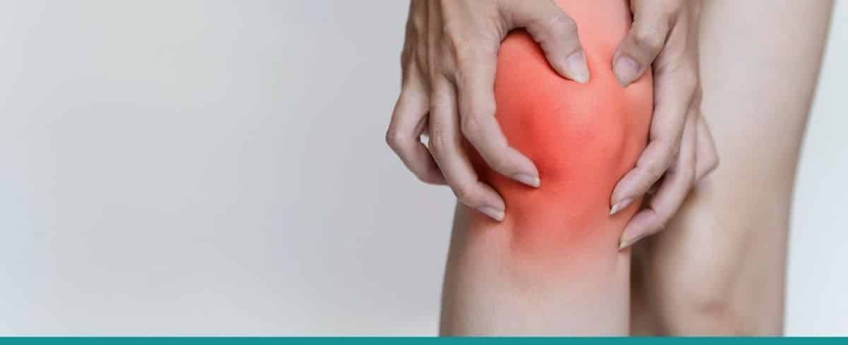 Close-up image of woman's knees with one knee highlighted in red and woman grabbing injured knee in pain
