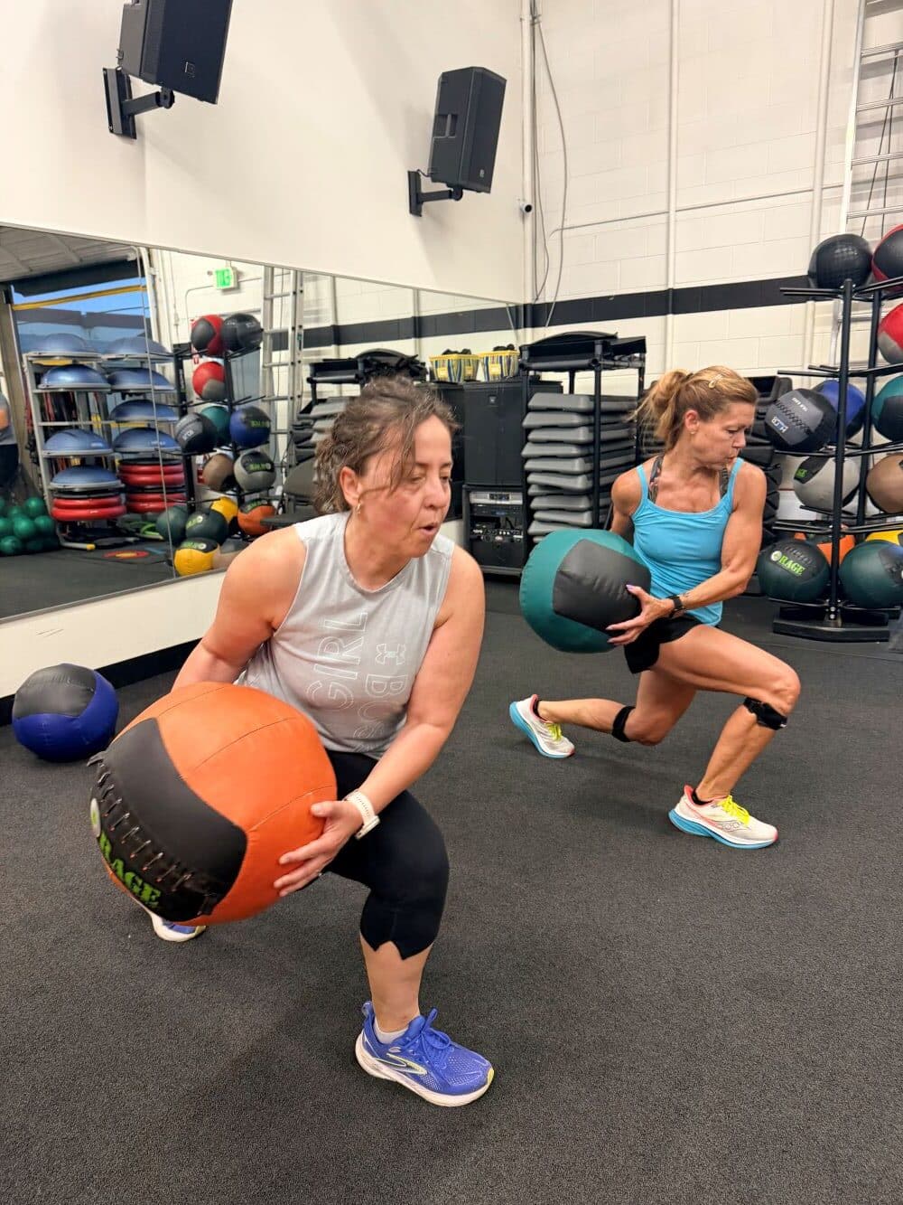 Two women doing wall balls at AFAC gym